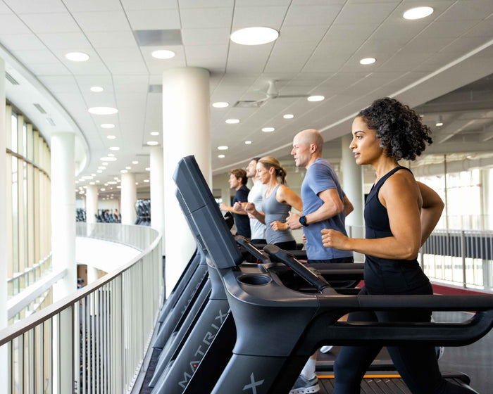 female and males running on matrix treadmills in gym setting