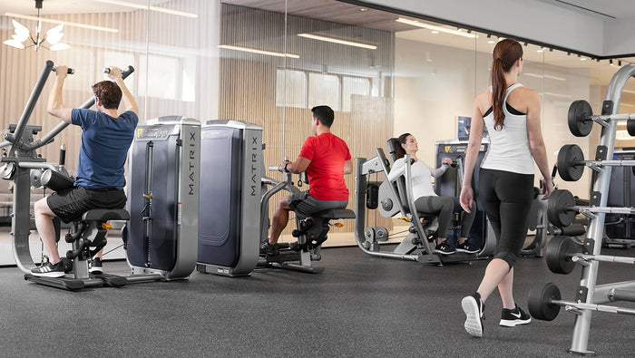 gym setting - 2 male 2 female using matrix equipment - lat pulldown, sated one arm row, seated chest press