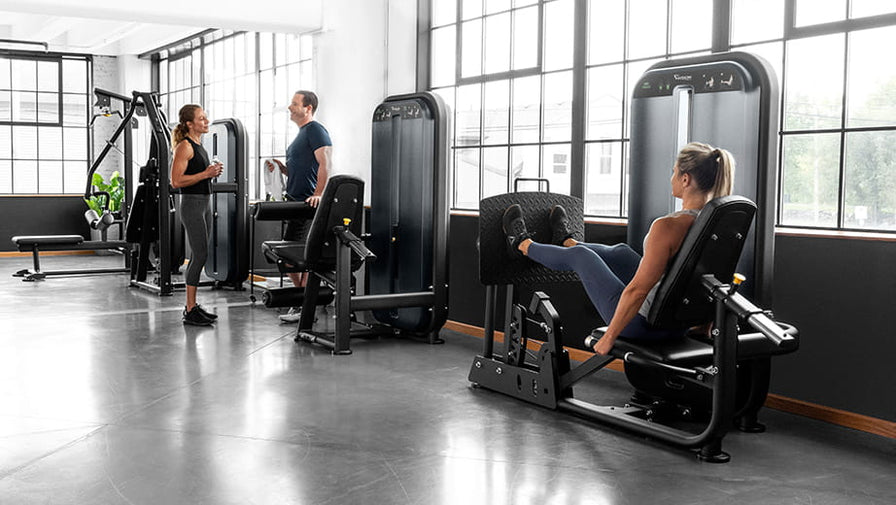 Lifestyle photograph 2 women and man using Vision Strength Gym Equipment in Gym Setting