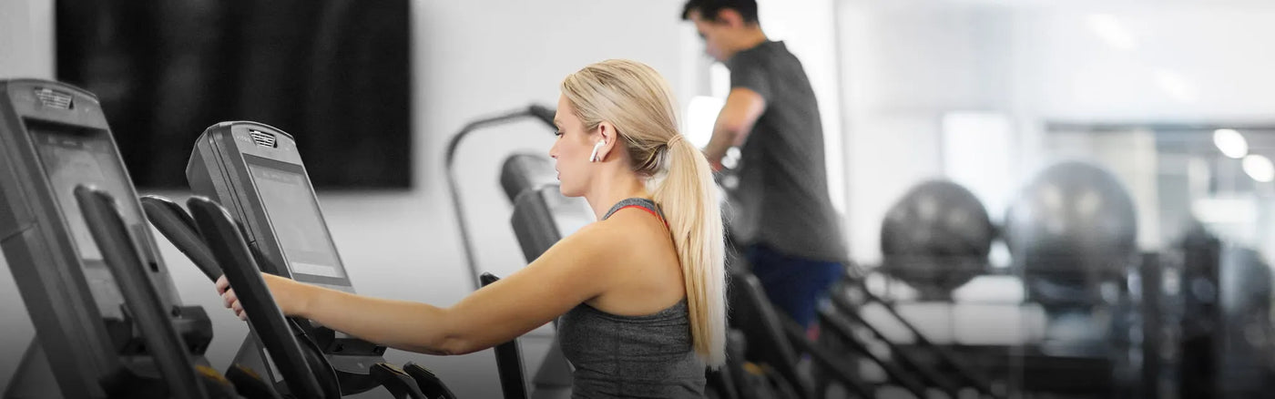 female and male - gym setting - elliptical and climbmill - banner photo