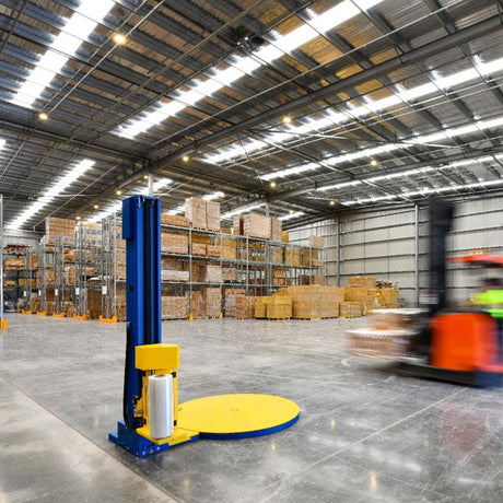 Warehouse interior with forklift and pallet jack.
