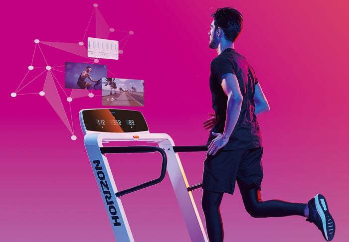 Man Running on Horizon Omega Z Treadmill with ATZONE feature display - pink background 