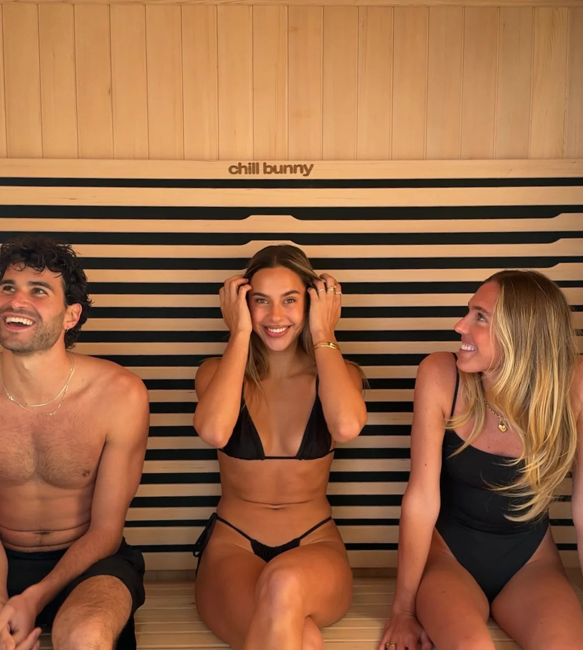 3 people sitting inside chill bunny indoor sauna - smiling 