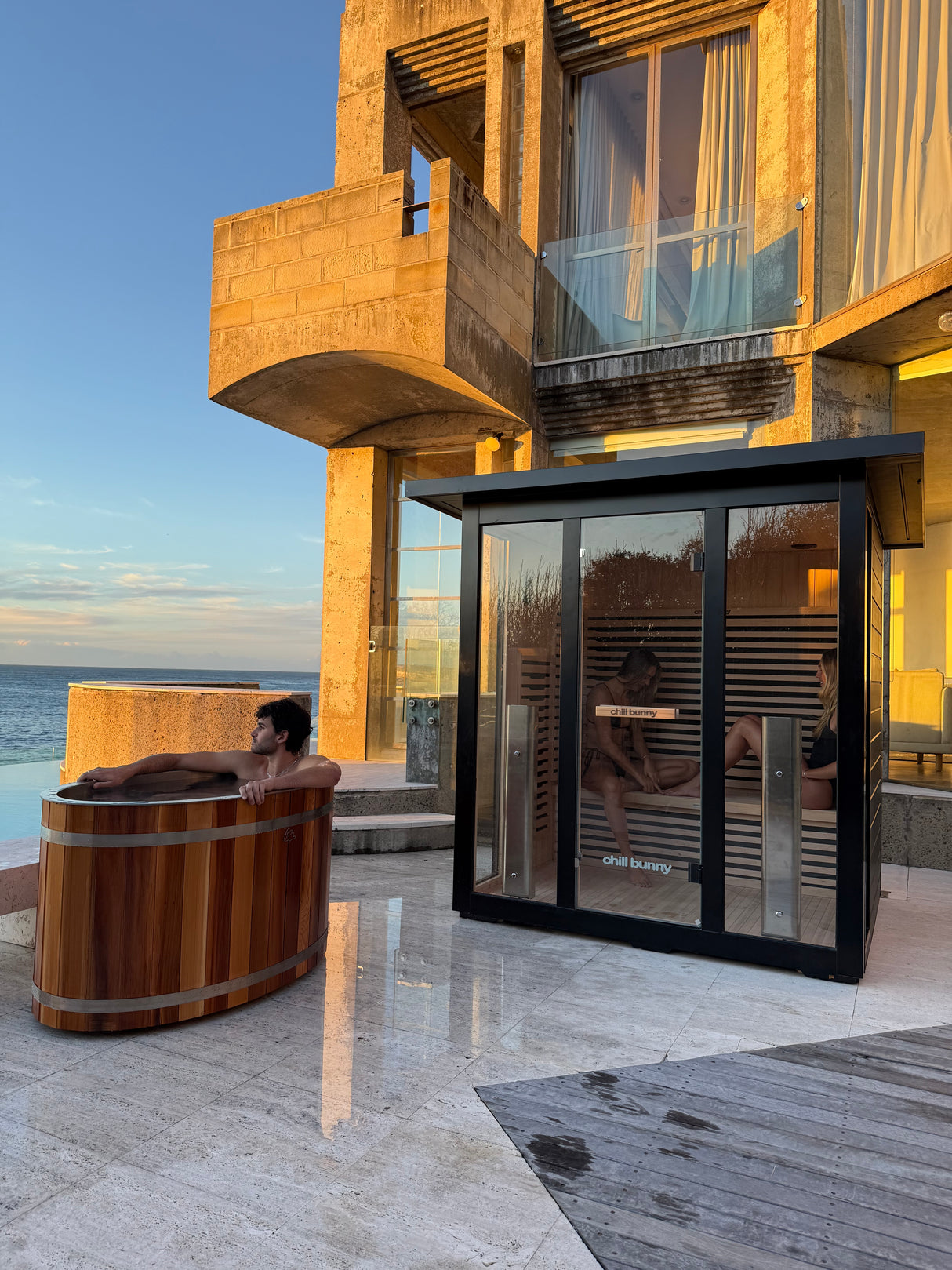 chill bunny outdoor sauna lifestyle vertical - 2 females in sauna, male in ice bath 